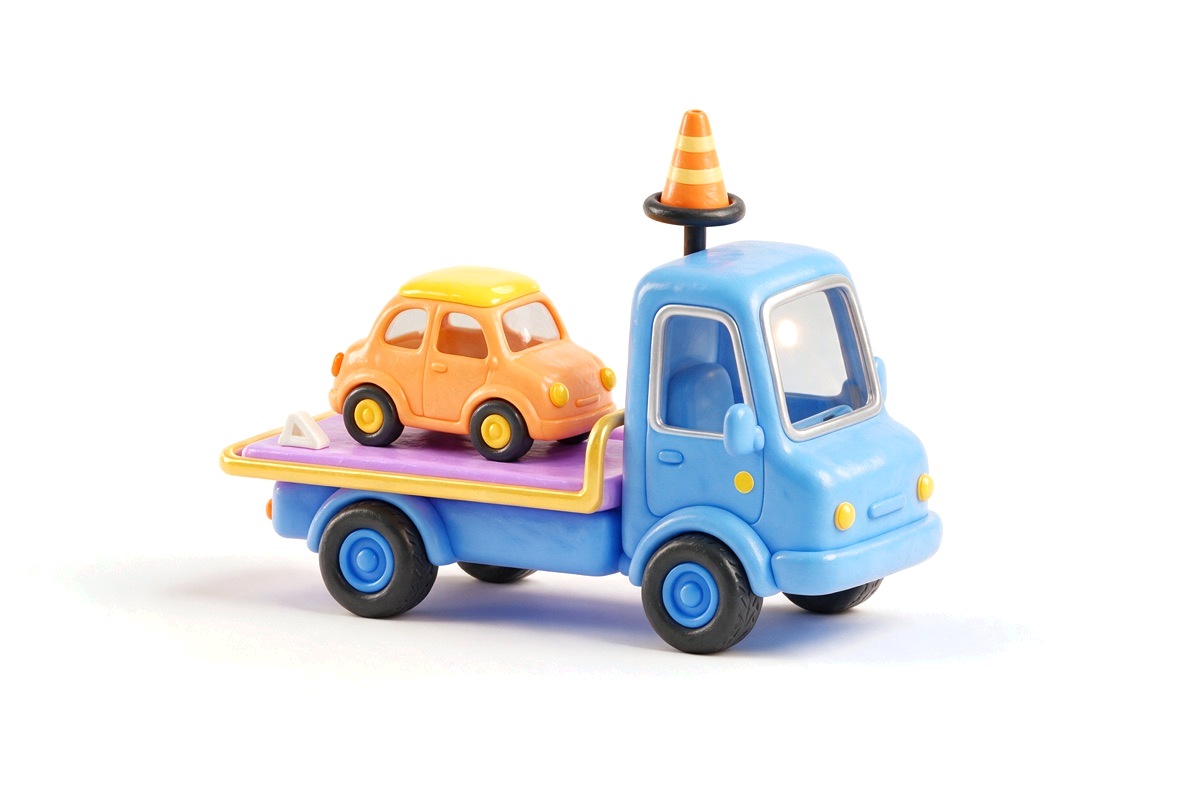 A blue tow truck carrying a small orange car with a traffic cone