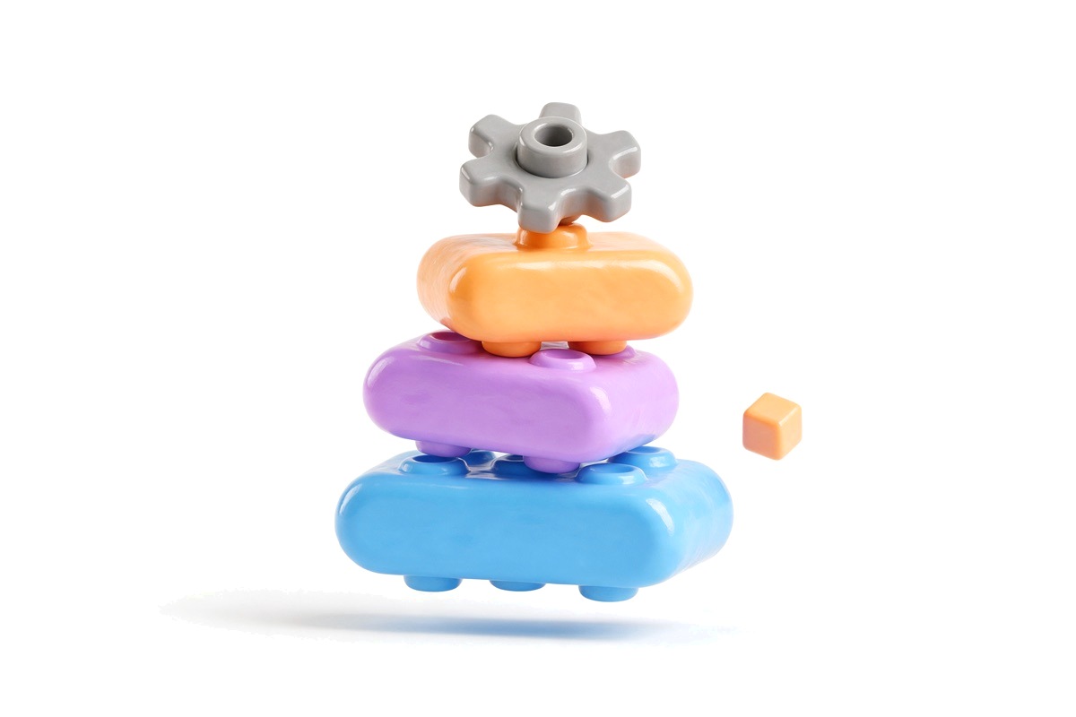 Glossy 3D stack of coloured building blocks with a gear on top