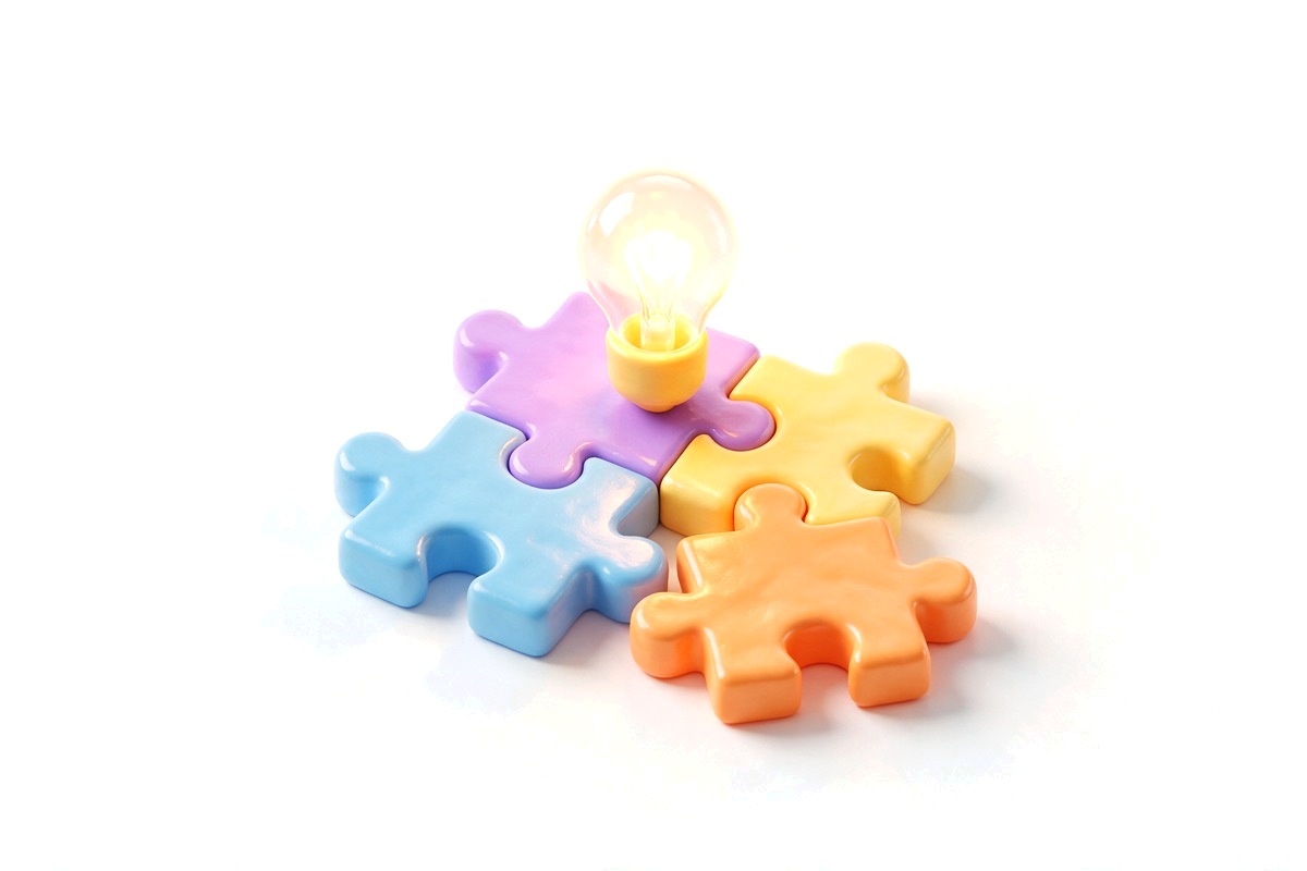 Interlocking puzzle pieces with an orange piece fitting in and a lightbulb