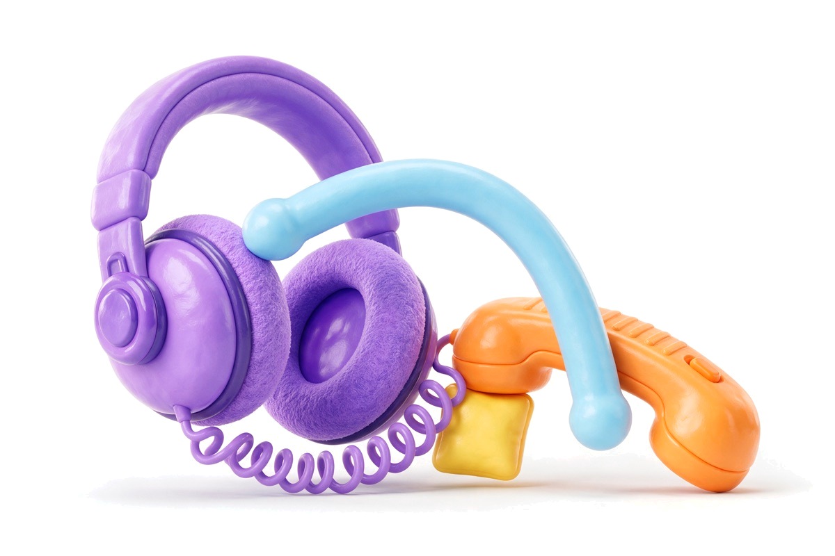 Headset connected by a curly cable to a phone handset with a baton between them
