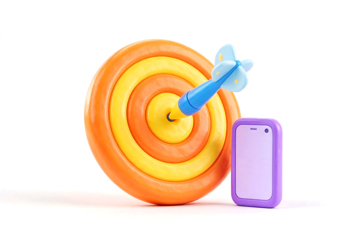 Bullseye target with a dart in the centre and a small phone beside it