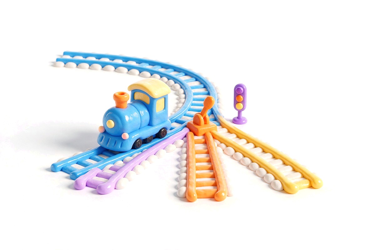 Toy railway track splitting into three paths with a train at the fork